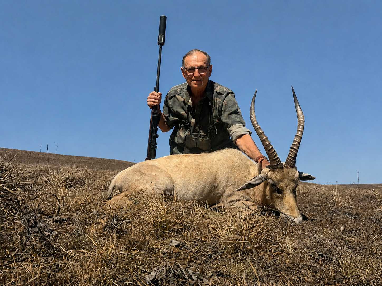 Hunter posing with a trophy antelope during a guided African hunting safari.