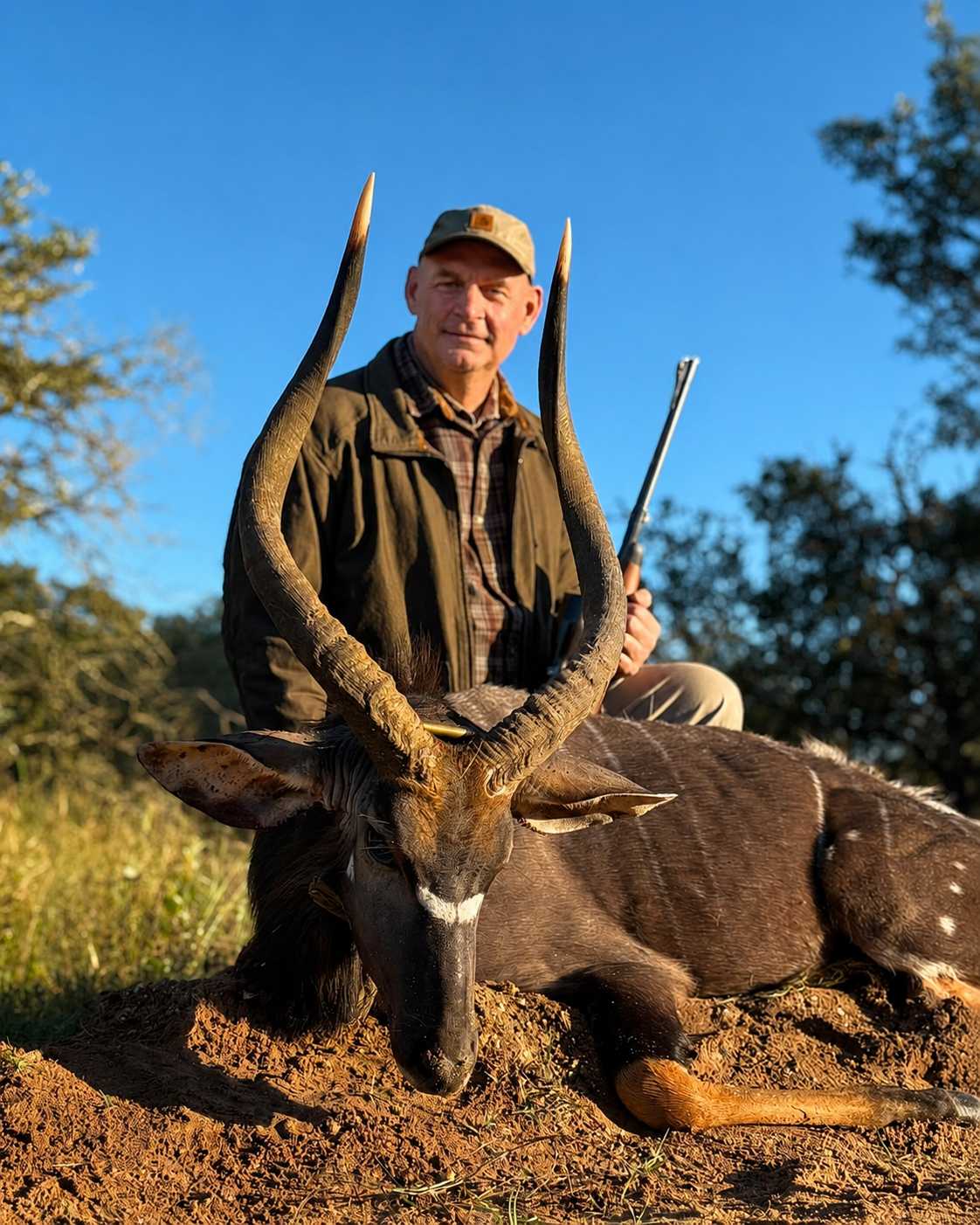Hunter posing with a trophy nyala after a successful hunting safari in South Africa