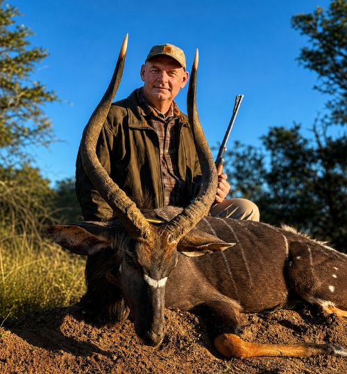 Hunter with a trophy nyala during a hunting safari in South Africa