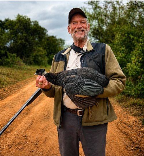 Hunter holding a guineafowl after a bird hunting safari in South Africa