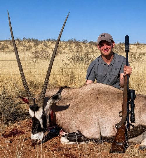 Hunter posing with a trophy gemsbok during a plains game hunting safari in South Africa